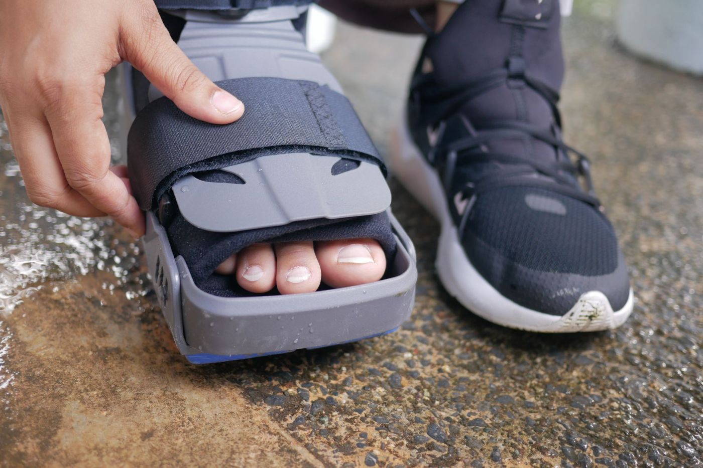 Close up of a person touching the walking boot that is protecting their foot